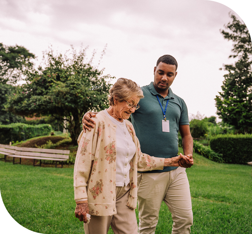 Elderly woman walking with caregiver outdoors